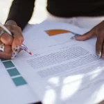 person editing a printed document with a pen
