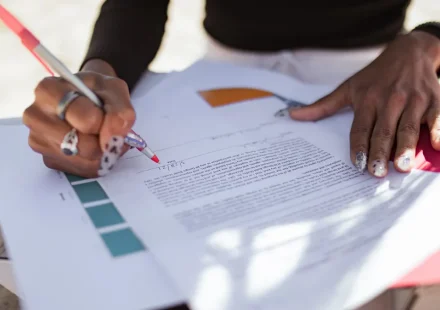person editing a printed document with a pen
