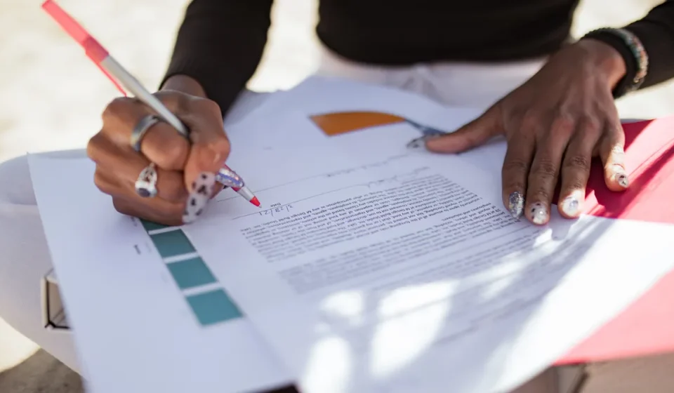 person editing a printed document with a pen