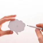 Hands holding and pointing at a speech bubble cutout