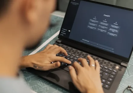 Person typing on laptop with AI chat interface