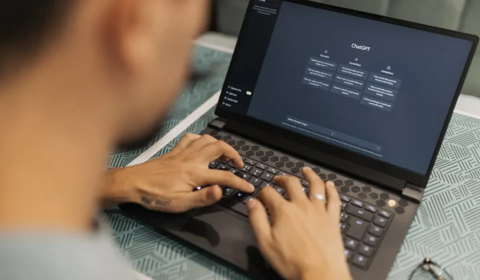 Person typing on laptop with AI chat interface