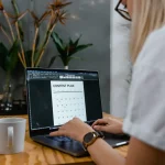 Person using laptop with a content plan calendar on screen