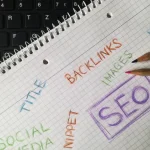 SEO notes on a notebook beside a keyboard