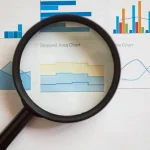 magnifying glass over analytics charts and graphs