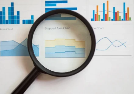 magnifying glass over analytics charts and graphs