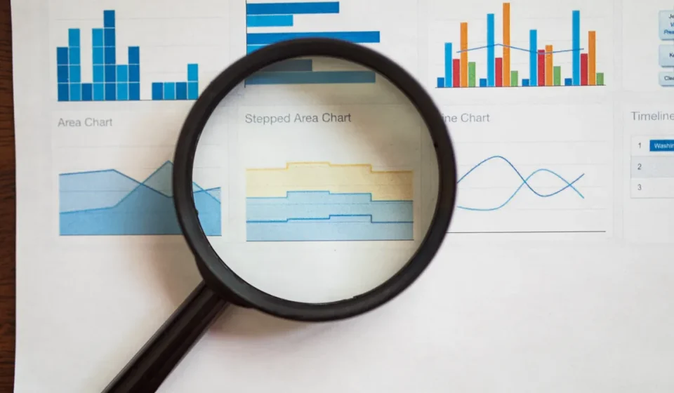 magnifying glass over analytics charts and graphs
