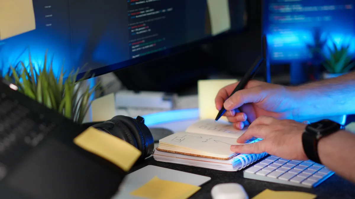 Best no-code automations for SEO workflows — Hands Writing Notes for Coding Project at Desk