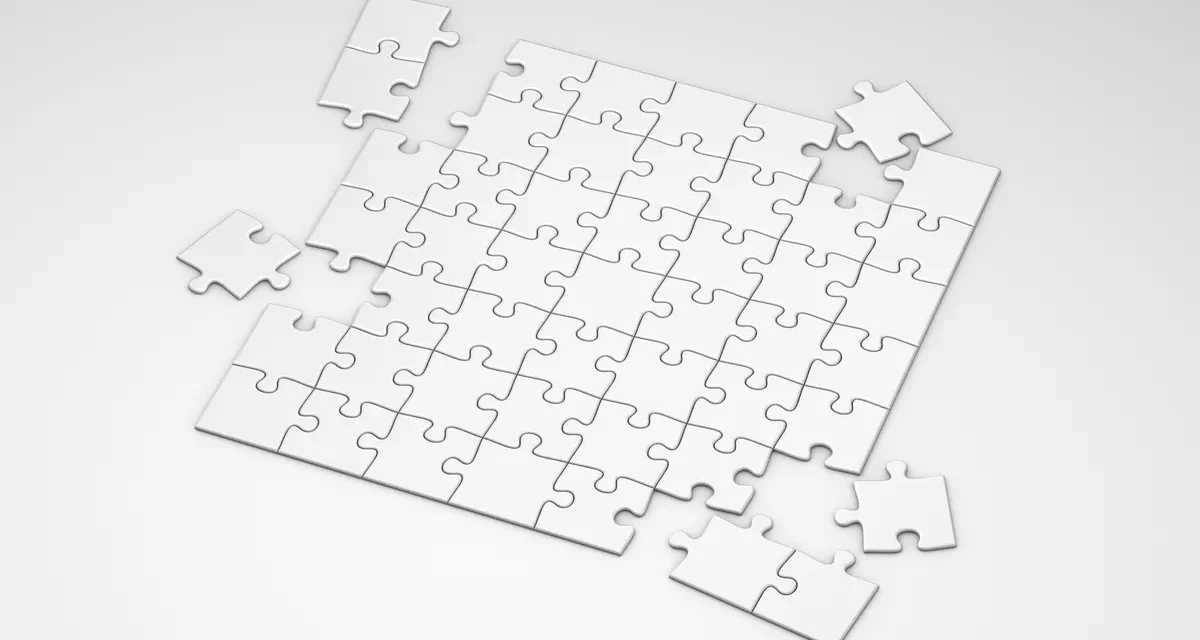 mostly assembled white jigsaw puzzle with a few loose pieces