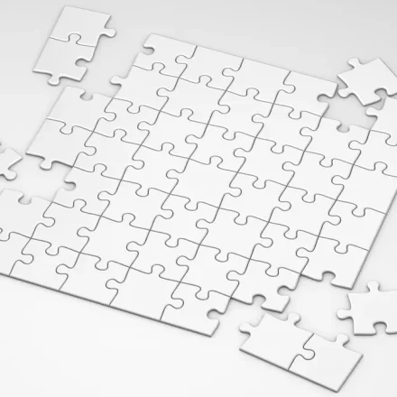 mostly assembled white jigsaw puzzle with a few loose pieces