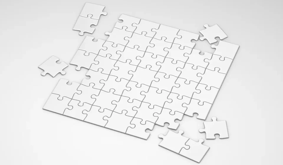 mostly assembled white jigsaw puzzle with a few loose pieces