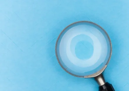 Magnifying glass on blue background