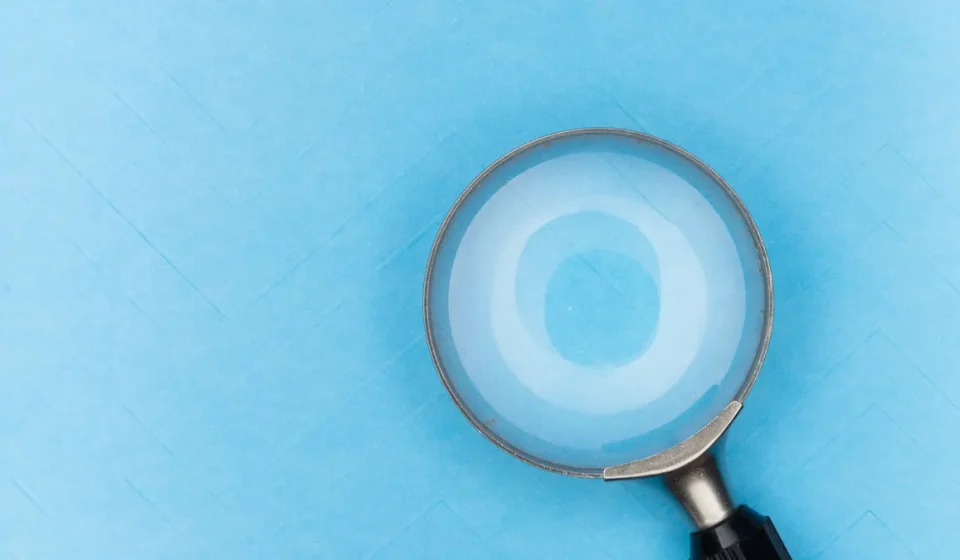 Magnifying glass on blue background