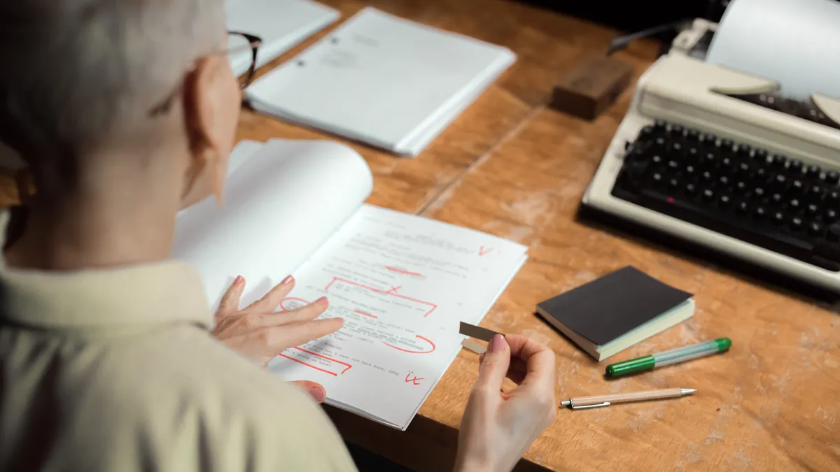 How to edit AI-written SEO drafts for brand voice Person reviewing and marking up a document at a desk